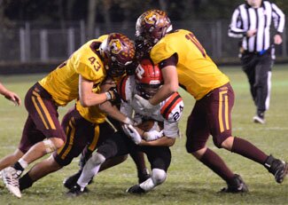 A swarm of Tiger tacklers, including Alex Larson (#43) and Alex Train (#10), smother a JM ball carrier during Stewies 51-7 win.