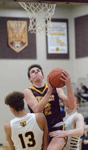 Will Tschetter is fouled by both Byron defenders while attacking the rim for two of his game-high 34 points.