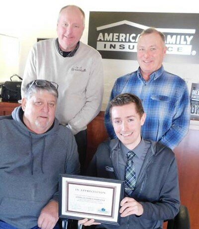 Tyler Welhaven, branch manager of Stewartville’s American Family Insurance office, seated at right, accepts the EDA’s Business Appreciation Award from, clockwise from lower left, Jim Kuisle, president of the EDA; Bill Schimmel Jr., city administrator; and Mayor Jimmie-John King, a member of the EDA.