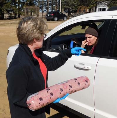 Tracy Hoover, a member of Racine United Methodist Church, left, prepares to give away a package of hamburger donated by 2 Brothers BBQ of Stewartville to a resident who pulled up to the church’s parking lot on Tuesday afternoon, March 31.