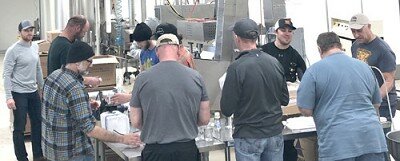 Above, workers from The Coffee Club at Jimmy’s Salad Dressings & Dips form an assembly line to bottle hand sanitizer from Harmony Spirits, a craft distillery from Harmony, Minn. Below is a bottle of the finished product, many of which will remain in Stewartville.