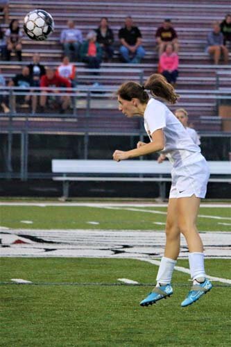 Tiger defender Alyssa Jones catches some air on this header to clear the defensive third against Triton.