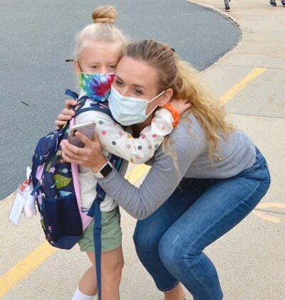 After being away from Stewartville’s school buildings for 191 days, students and teachers returned to their classrooms on Monday, Sept. 14. At right, Leigh Dzubay hugs her daughter, Juliette, who started her first day of kindergarten at Bonner Elementary School that morning.