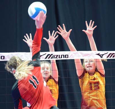 Tigers Ally Elliott (left) and Erin Lamb (#13) block the kill attempt of a North Branch hitter in the 2019 1AA State Championship match.