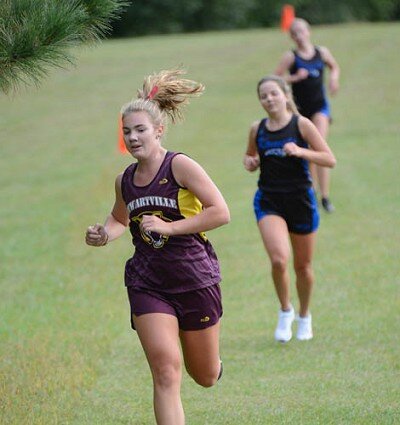 Olivia Field increases her lead, lengthening her stride down a hill.