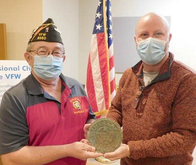 Jim Parry, REACH coordinator at Stewartville High School-Middle School, right, shares a grave marker inscribed with the name of World War I veteran Charles Lenton with Roger Peterson, commander of the Stewartville American Legion Post 164. Parry found the marker while using his metal detector at Bear Cave Park.
