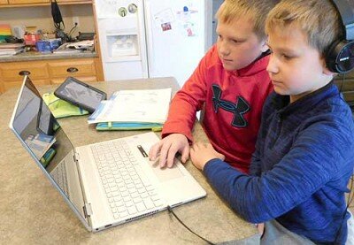 Carsen Nagel, 7, a first grader at Bonner Elementary School, foreground, and his older brother Caden, 11, a fifth grader at Bear Cave Intermediate School, sit at the kitchen island in their Stewartville home as they prepare for distance learning, scheduled to begin for all K-12 students in the Stewartville School District this Wednesday, Dec. 2 and continue through Friday, Jan. 15.