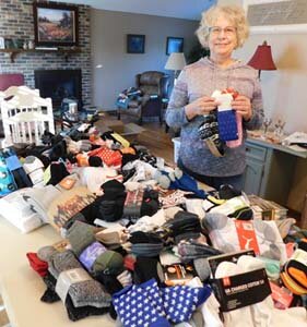 Carol Youdas, a member of the Stewartville Kiwanis Club and chair of the club’s annual “Sock It To ‘Em” Sock Drive, displays many of the more than 450 pairs of socks local and area residents brought to Bremer Bank from Monday, Nov. 2 through Monday, Nov. 30. The socks will be distributed to Stewartville schools and The Landing MN in Rochester, which serves homeless people, Youdas said.