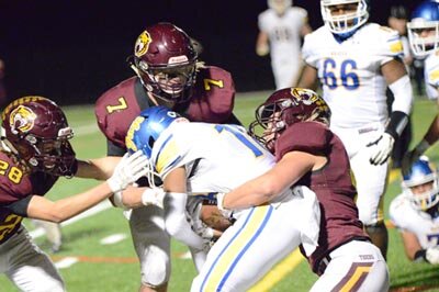 Tiger junior linebacker Riley Eickhoff (#7) assets on the tackle with teammates Will Laures (left) and Eddie Becker.