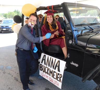 Anna Buckmeier, a highest honors graduate with the Stewartville High School class of 2020, smiles brightly as she accepts her diploma from Patrick Breen, principal of SHS, during the drive-up graduation ceremony and student parade on Sunday, June 7.