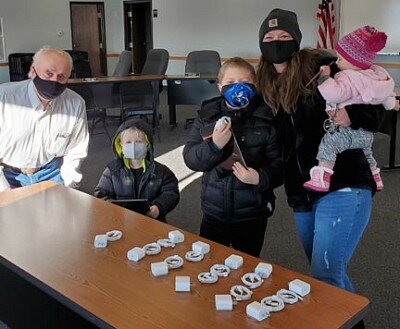 Racine Mayor Deri Nordsving, left, who helped distribute iPads to Stewartville School District students from Racine on Saturday morning, Jan. 2, poses with the Passow family, including, from left, Owen, Ivan, Mom Jodi, and baby Etta.