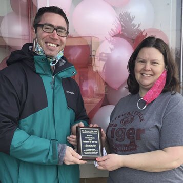 Jen Schurmeier, right, accepts the Stewartville Area Chamber of Commerce's Volunteer of the Year Award from Jared Johnson, Chamber president for 2021. Schurmeier earned the honor for decorating many Stewartville storefronts for Christmas and Valentine's Day.