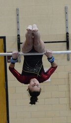 Meghan Urban executes a pull over during her routine on the bars.