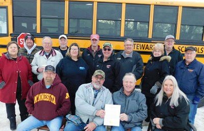 Mayor Jimmie-John King, seated second from right, signed a proclamation last week declaring Feb. 23 School Bus Driver Appreciation Day in Stewartville. Seated in the front row with the mayor are, from left, Bryan Runkle, manager of Grisim School Bus, Inc., and Curt and Connie Grisim, owners. A few of the 38 drivers for Grisim Bus include, second row, from left, Martha Eyler, Dick Uptagrafft, Sheila Cada, Kevin Capelle, Pauline Fontaine and Steve Sturm. Back row, from left, Corey Grisim, Roger Langseth, Clif Giest, James Deppa and Chris Negley.